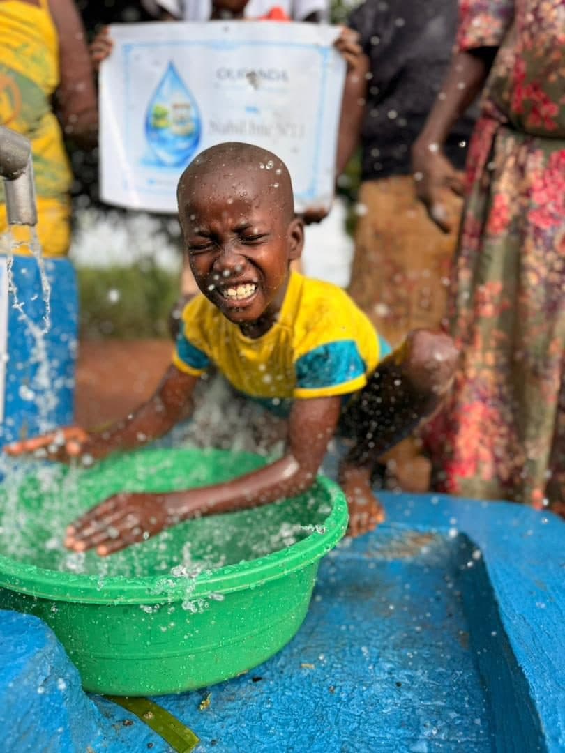 Le même enfant, les mains dans l'eau claire